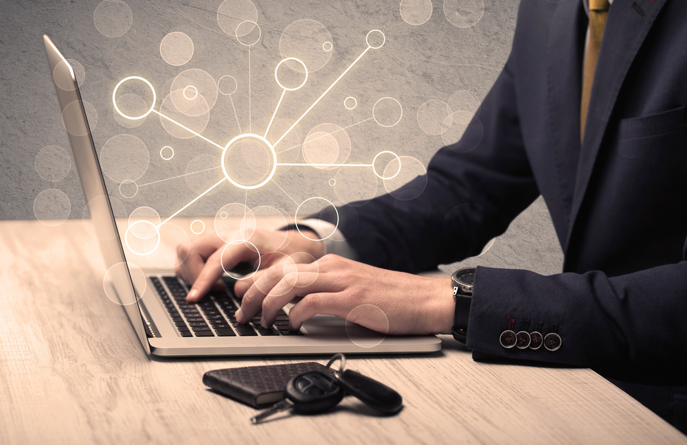 An office salesman in elegant suit working on a scientific project with the help of a laptop concept